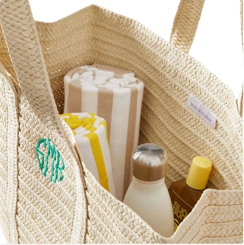 Straw beach bag material with woven texture and reinforced long handle stitching Straw beach bag material with woven texture and reinforced long handle stitching